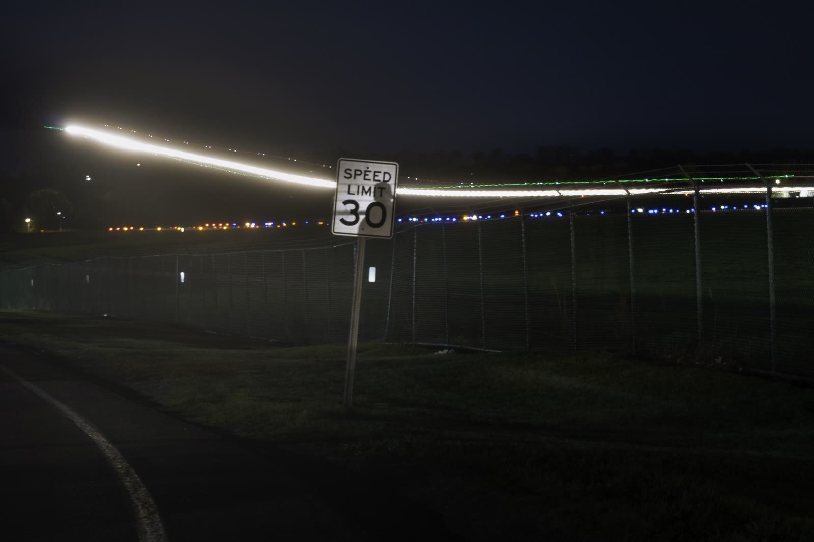 From "Time Flies," light trails passing a speed limit sign at night.